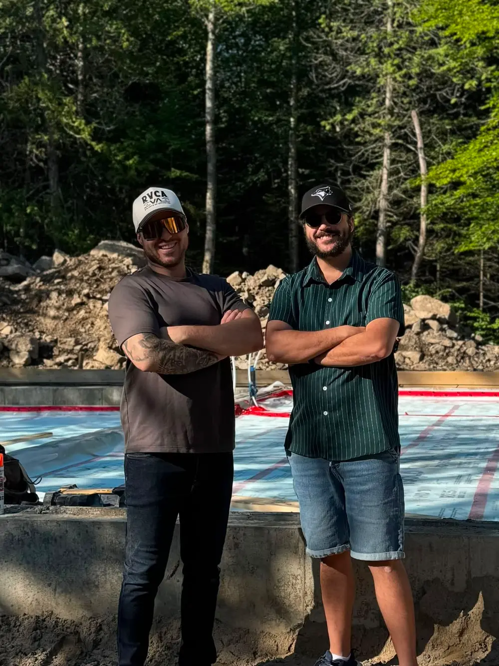 Alexandre Pelletier et Simon Lafortune debout devant la fondation d’une maison en construction